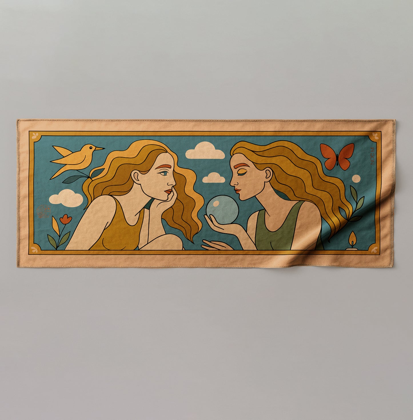 a colorful silk or chiffon pareo/sarong of two women with a bird and butterfly on a blue background.