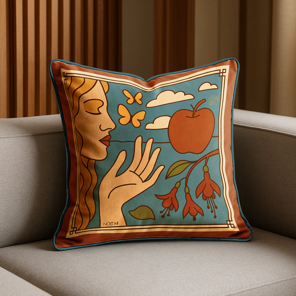 Decorative luxury velvet pillow with artistic design of a woman, apple, and flowers on a couch.