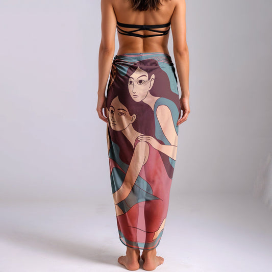 Woman wearing a colorful silk or chiffon pareo/sarong with artistic design on a plain background