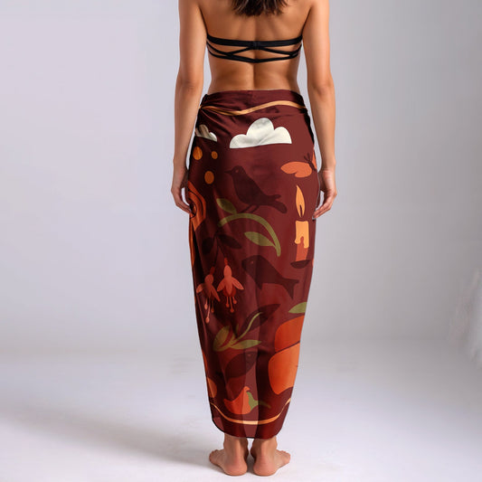 Woman wearing a colorful silk or chiffon pareo/sarong on a plain background