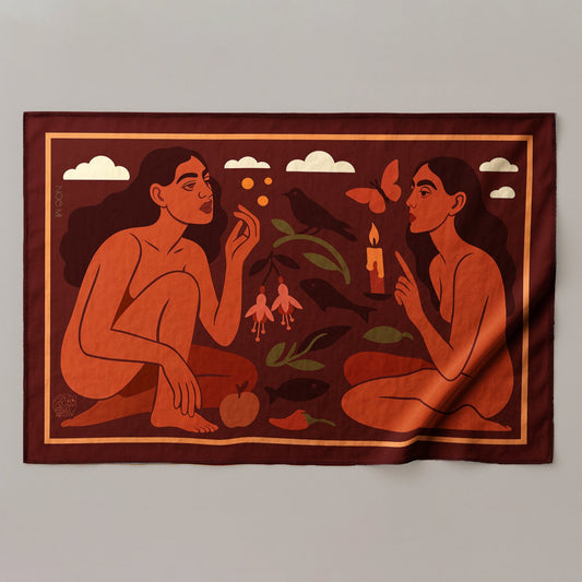 a colorful silk or chiffon pareo/sarong of two figures with nature elements on a fabric background