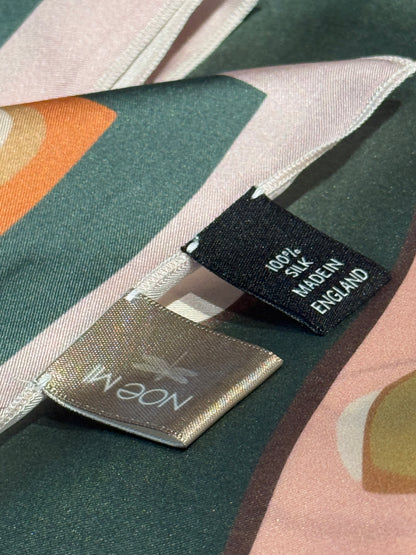 Golden Threads silk scarf from NOE MI, collectible square scarf with surreal feminine figure and symbolic details, in blush and olive palette.