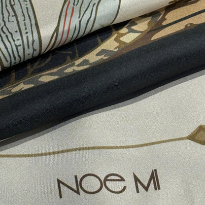 High-end silk scarf by NOE MI, The Navigator print featuring symbolic feminine portrait, wheel, dragonflies, and surreal decorative motifs.