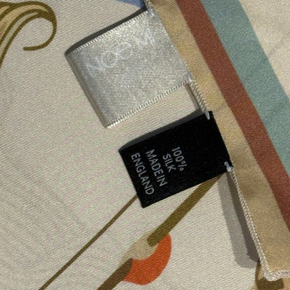 Luxury silk scarf The Navigator by NOE MI, artistic square scarf in cream and gold tones with surreal symbols and feminine storytelling.