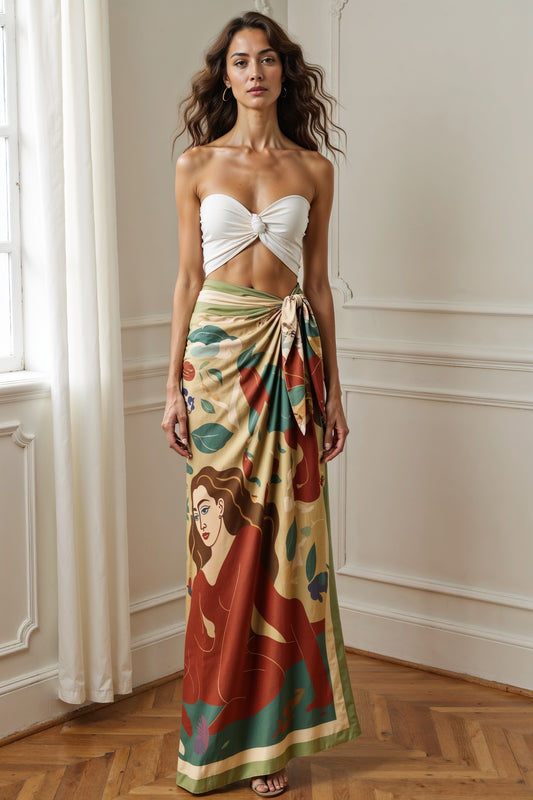 Woman wearing a colorful ART chiffon pareo by NOE MI with a floral pattern in a room with wooden flooring and white walls.